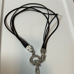 black braided leather belt with ornate silver-tone hardware.